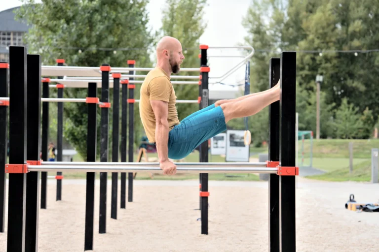 Výdrž s nohama vpřed na bradlech na venkovním hřišti